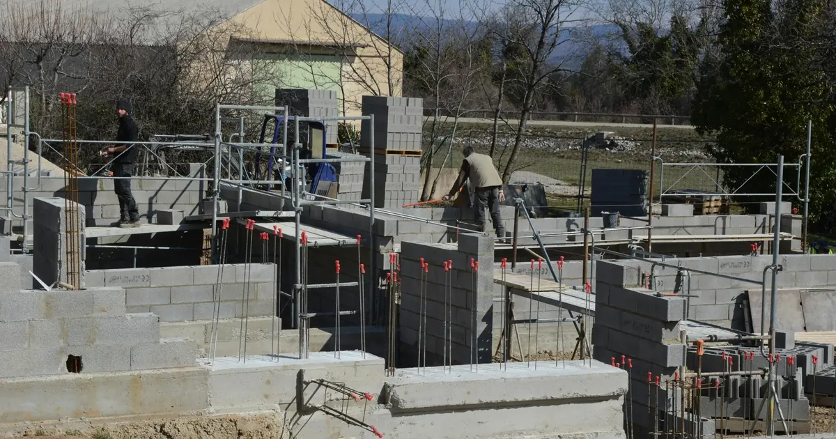 Concrete masonry block walls under construction with scaffolding on an active job site
